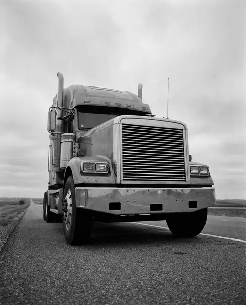 18-wheeler truck cab and front wheels on a highway shoulder
