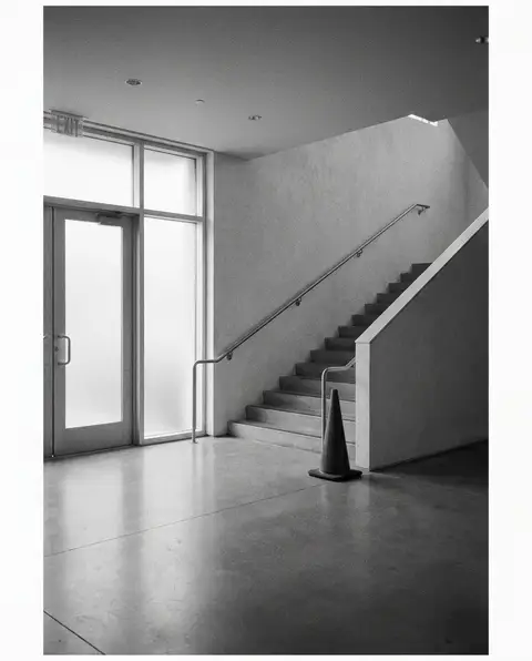 Hazard cone at the base of a staircase in an empty building lobby