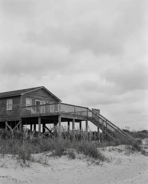 Coastal vacation rental beach house with an elevated deck and exterior stairs